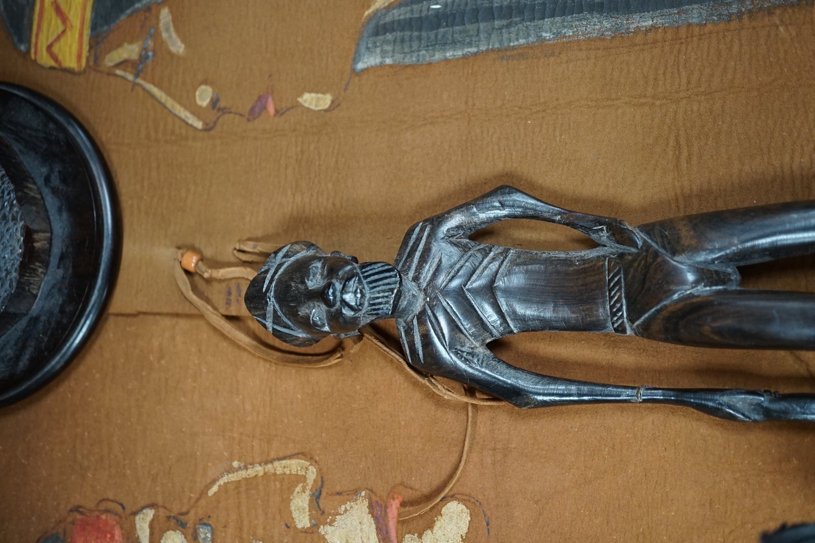 Two Native American paintings on leather and two carved hardwood figures, tallest hardwood figures 40cm high